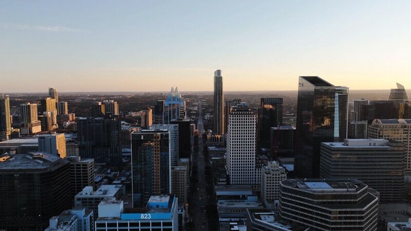 Downtown Austin skyline at dusk from altitude, Congress Avenue running to the horizon